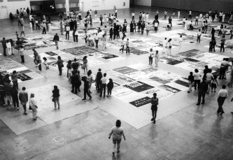 Folks viewing the AIDS memorial quilt at the Tom McEnery Convention Center hosted by ARIS. Photograph from the Ted Sahl Archives at SJSU.
